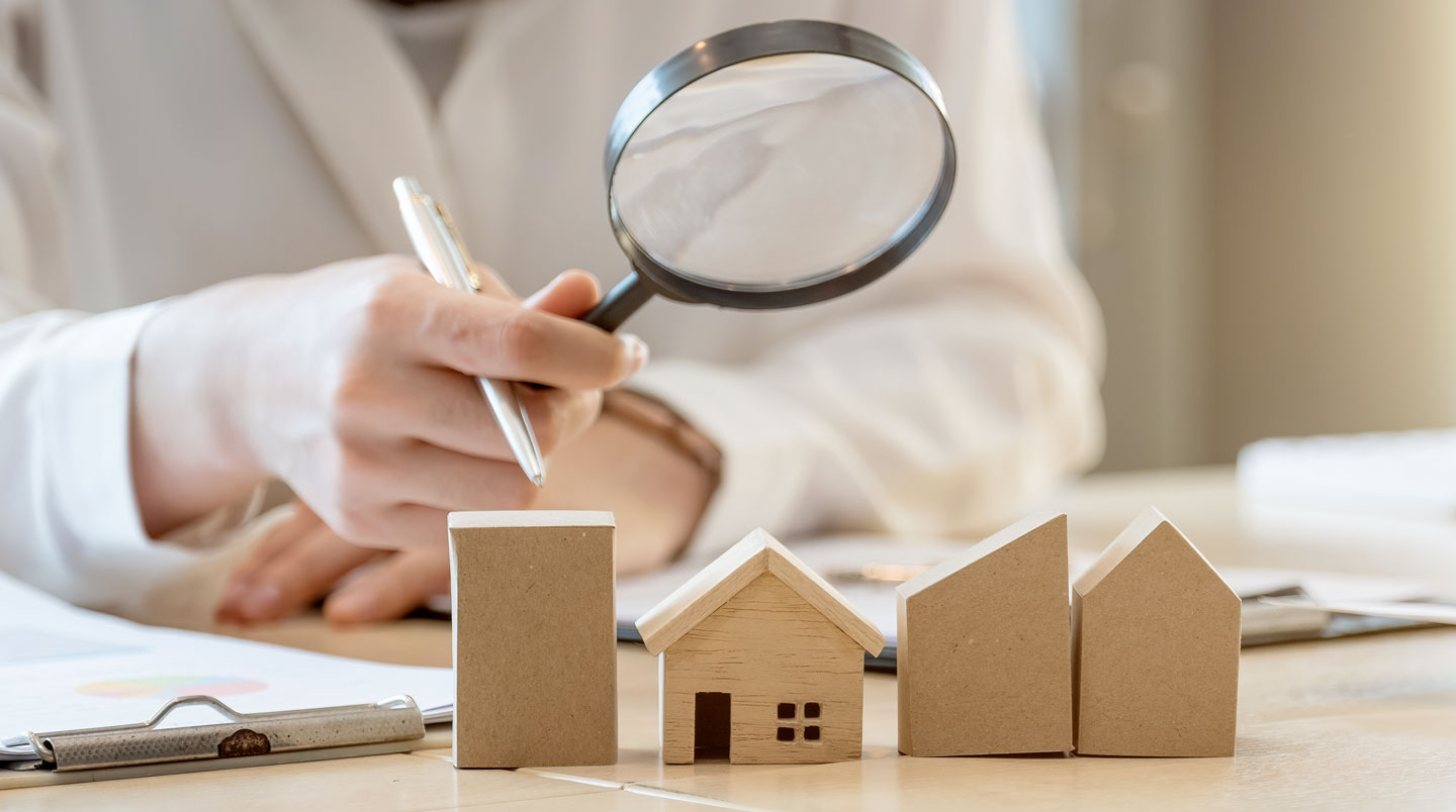 Salle de séance vide avec des plans d'appartement et des documents d'évaluation étalés sur une grande table en verre